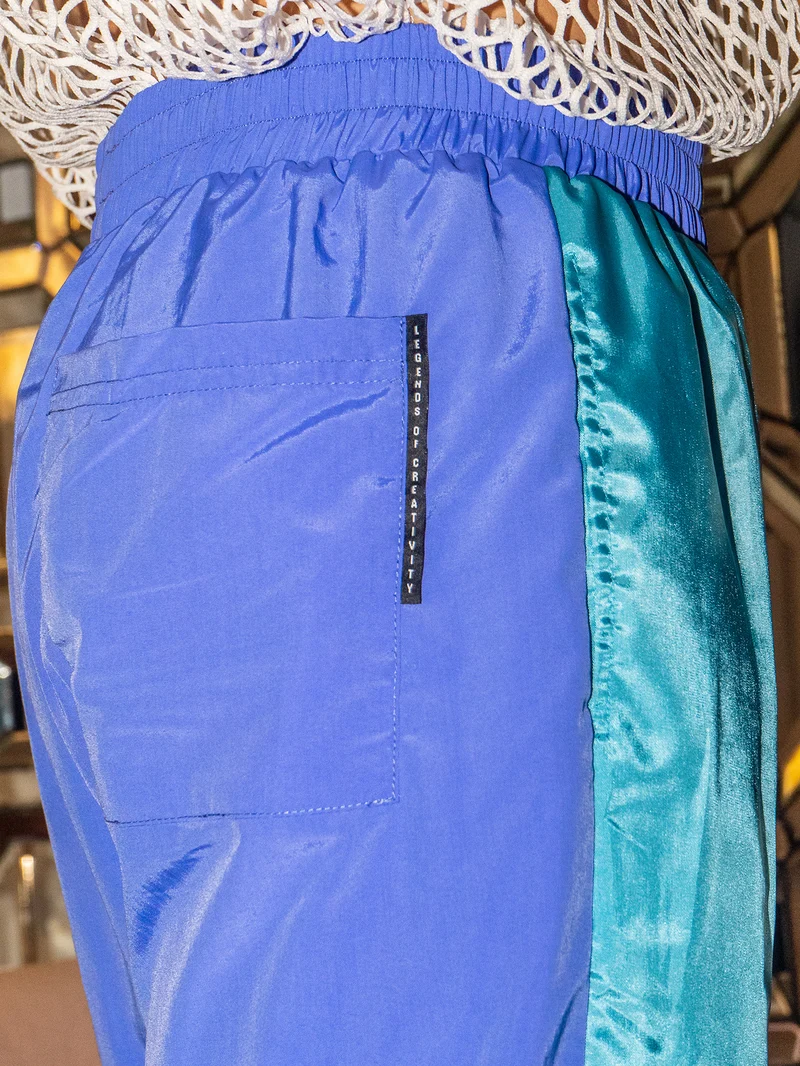 Detail of the pocket on blue and teal trousers