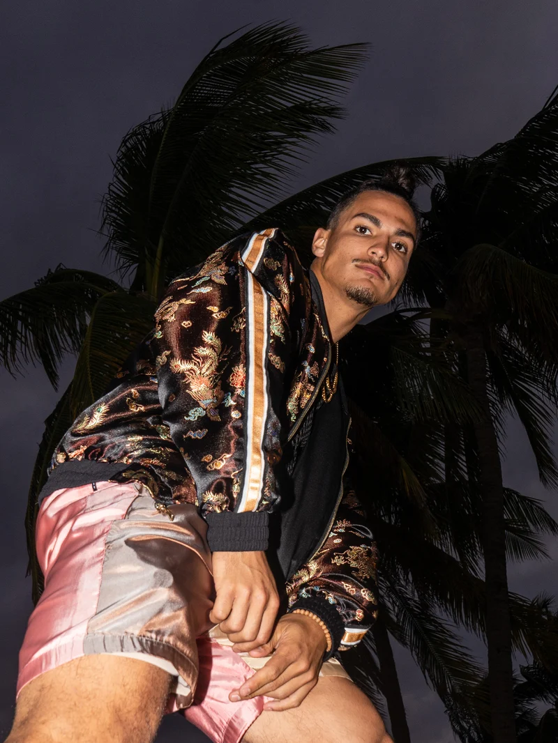 Low-angle view of a model in a black dragon brocade bomber