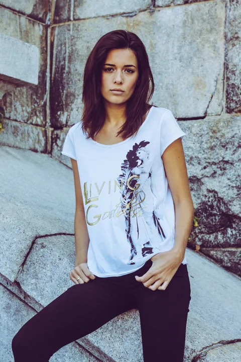 New York campaign model wearing a white printed T-shirt beside a stone wall