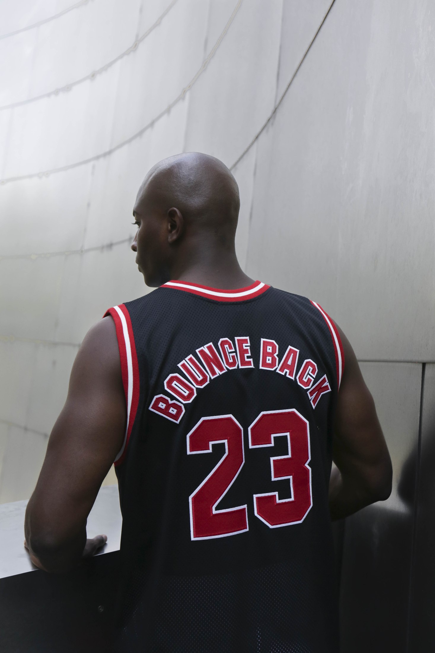 Back view of a black numbered basketball jersey with red trim